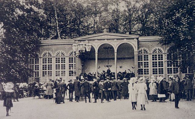 Photo from around 1900 showing people in elegant dresses in front of a representative building